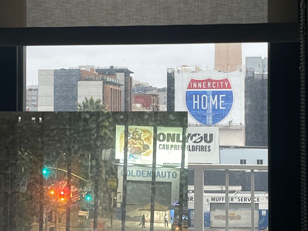 a firetruck leaving late past a barred billboard telling "only you can prevent wildfires" to city buildings